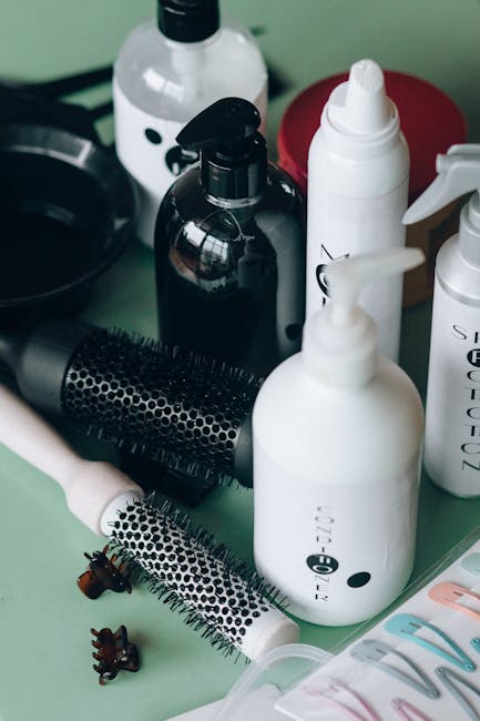 Close-up of hairstyling tools and cosmetic bottles on a green background for salon use.